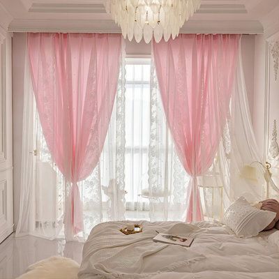 a white bed sitting under a window next to a chandelier