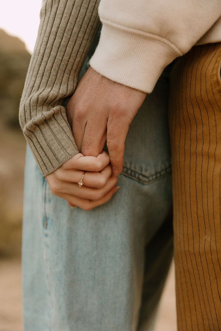 two people holding hands while standing next to each other