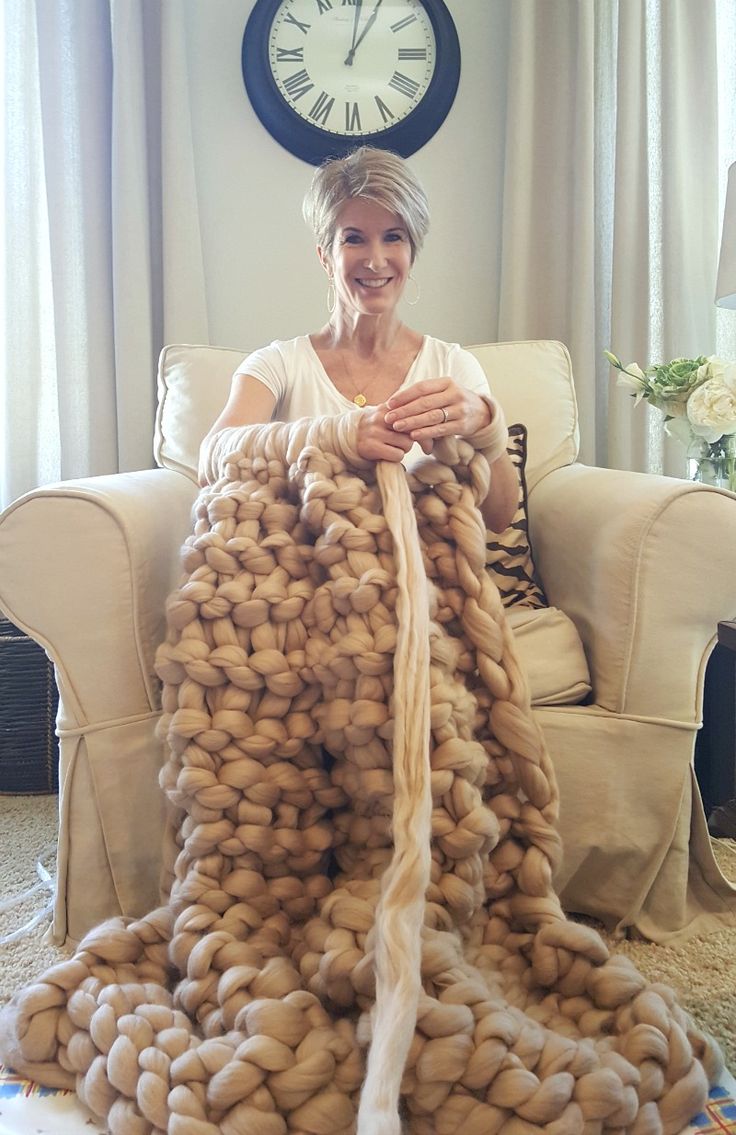 a woman sitting on a couch covered in yarn