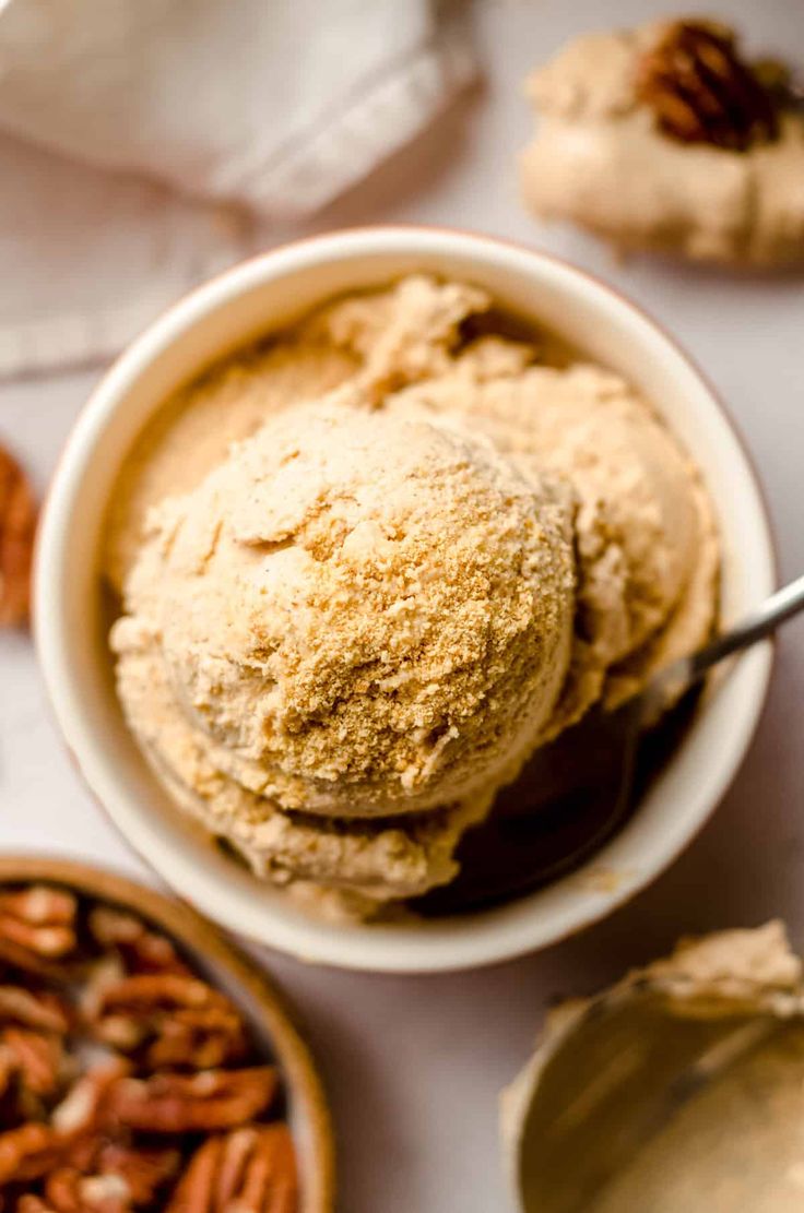 a bowl filled with ice cream next to pecans