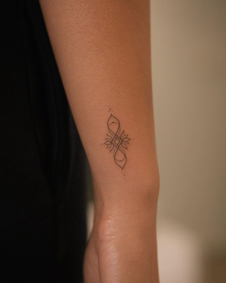 a woman's arm with a tattoo design on the left side of her wrist