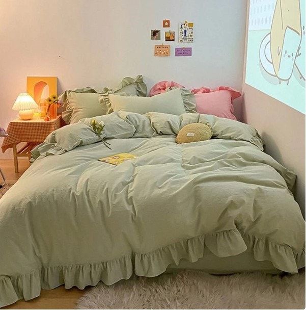 a bed room with a neatly made bed and a projector screen on the wall