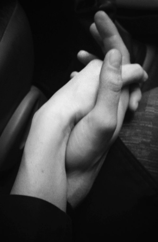 two people holding hands while sitting down