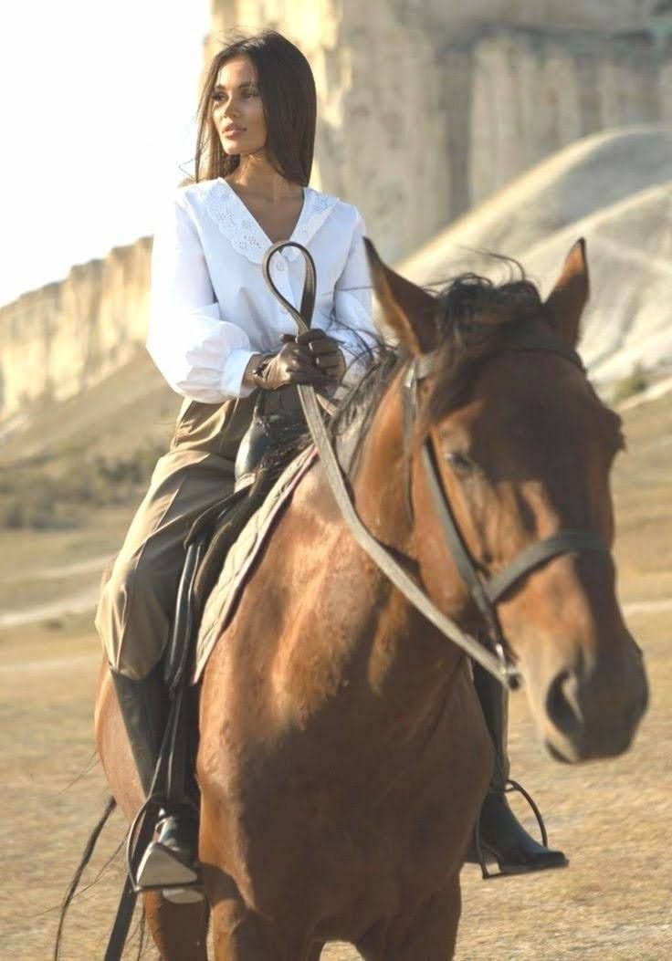 a woman riding on the back of a brown horse