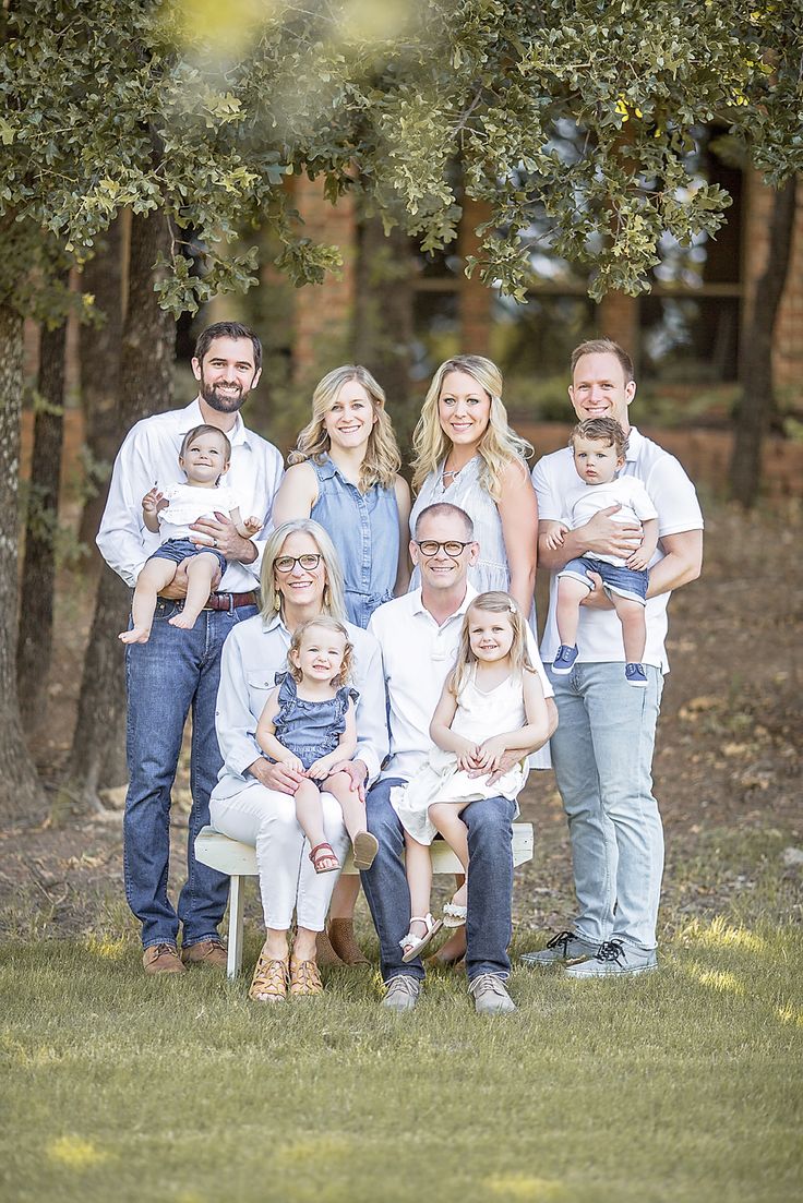 a family posing for a photo in front of some trees