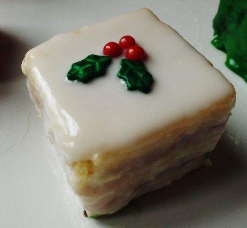 a piece of cake sitting on top of a white plate next to green leafy decorations