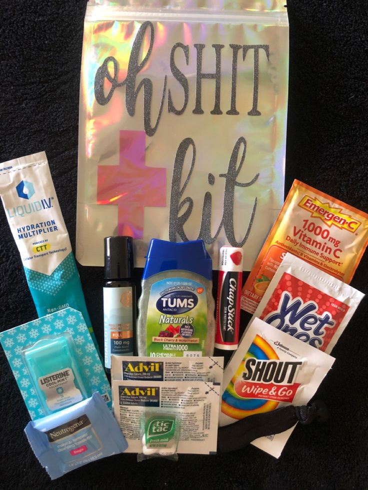 an assortment of toiletries sitting on top of a black carpet next to a bag