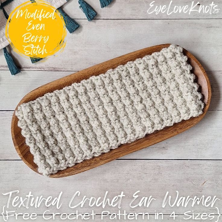 the textured crochet ear warmer pattern is shown on a wooden platter