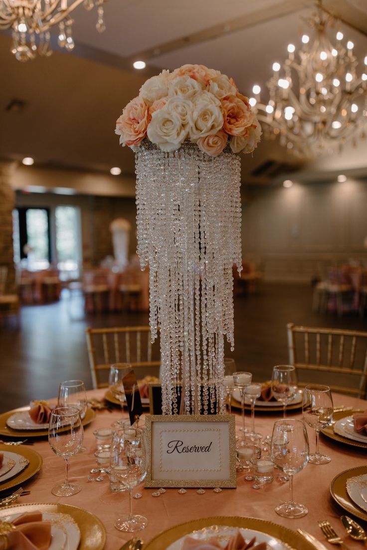 an elegant table setting with chandelier and flowers