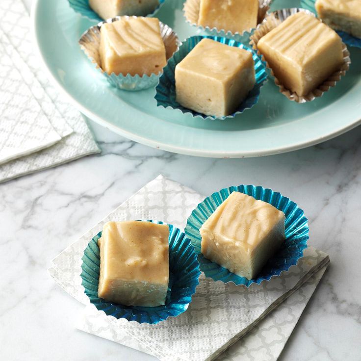 several pieces of peanut butter fudge sitting on top of a blue plate next to silverware