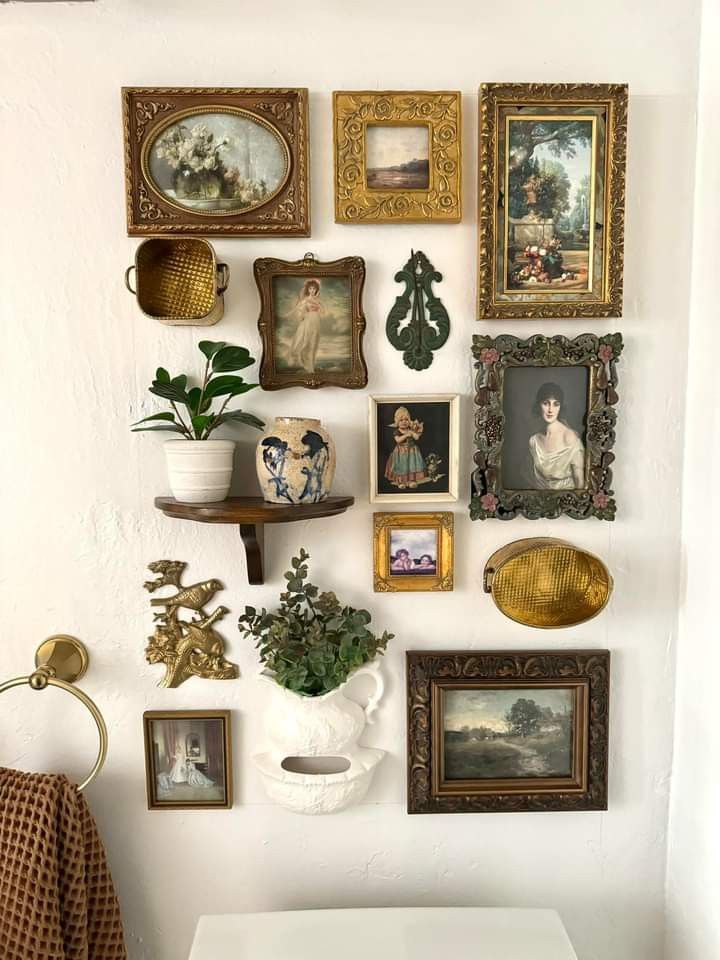 a white toilet sitting next to a wall filled with pictures and plants on top of it