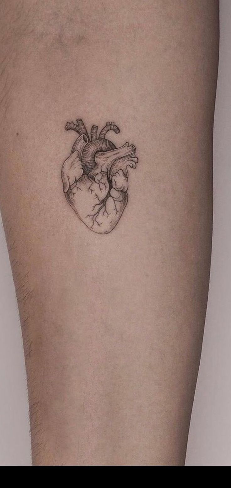 a small heart tattoo on the right thigh, with an arrow in it's center