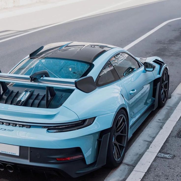 a blue sports car is parked on the side of the road