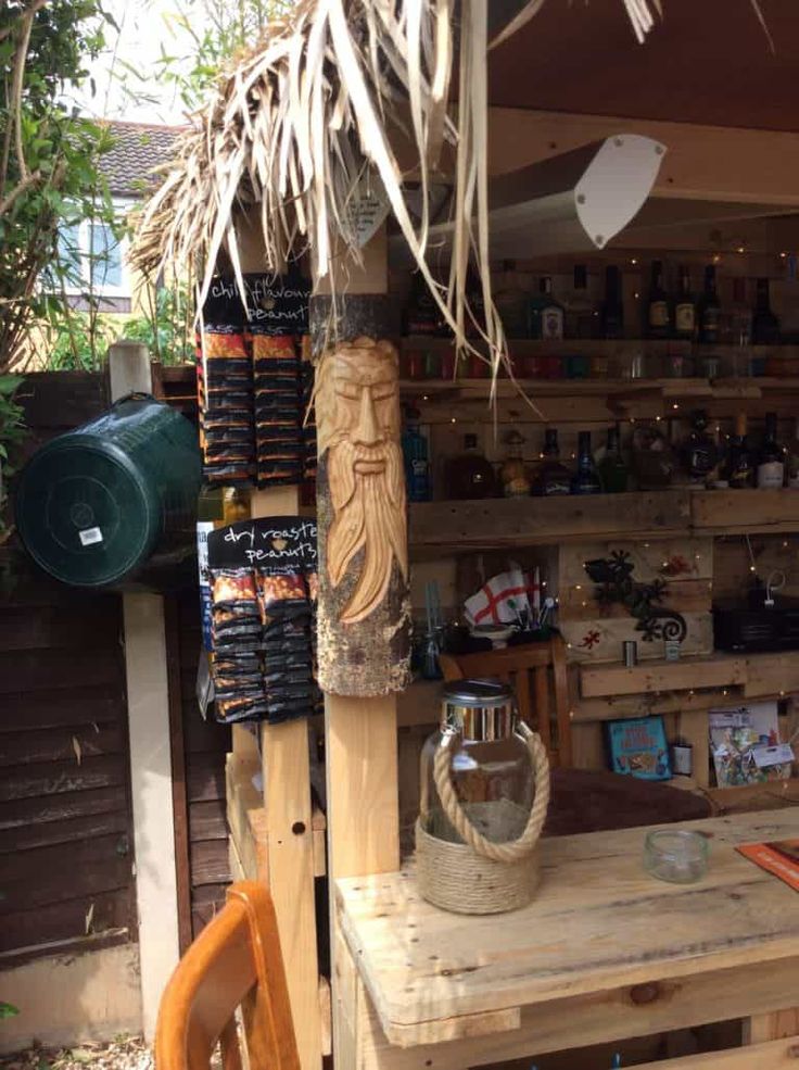 a wooden table sitting in front of a store filled with lots of bottles and other items