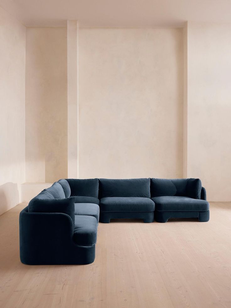 a large blue sectional sofa in an empty room