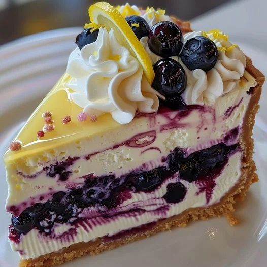 a slice of cheesecake with blueberries and lemon on top