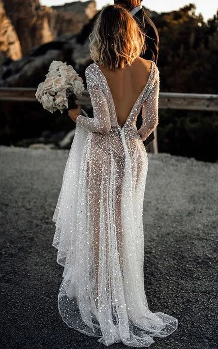 the back of a bride's dress with sequins on it and her bouquet