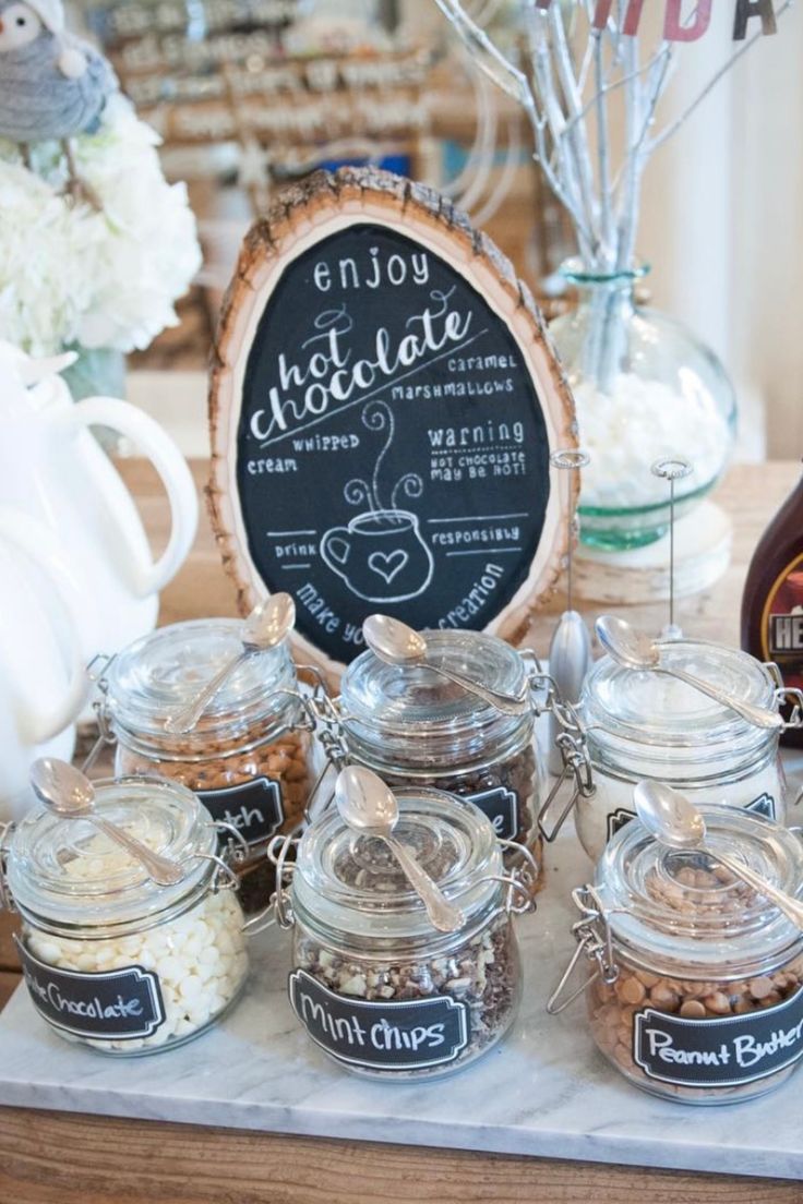 there are many jars with food in them on the table next to a sign that says enjoy chocolate