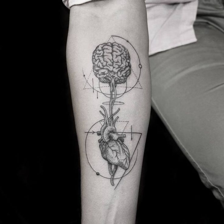 a person with a tattoo on their arm has a drawing of a heart and a tree