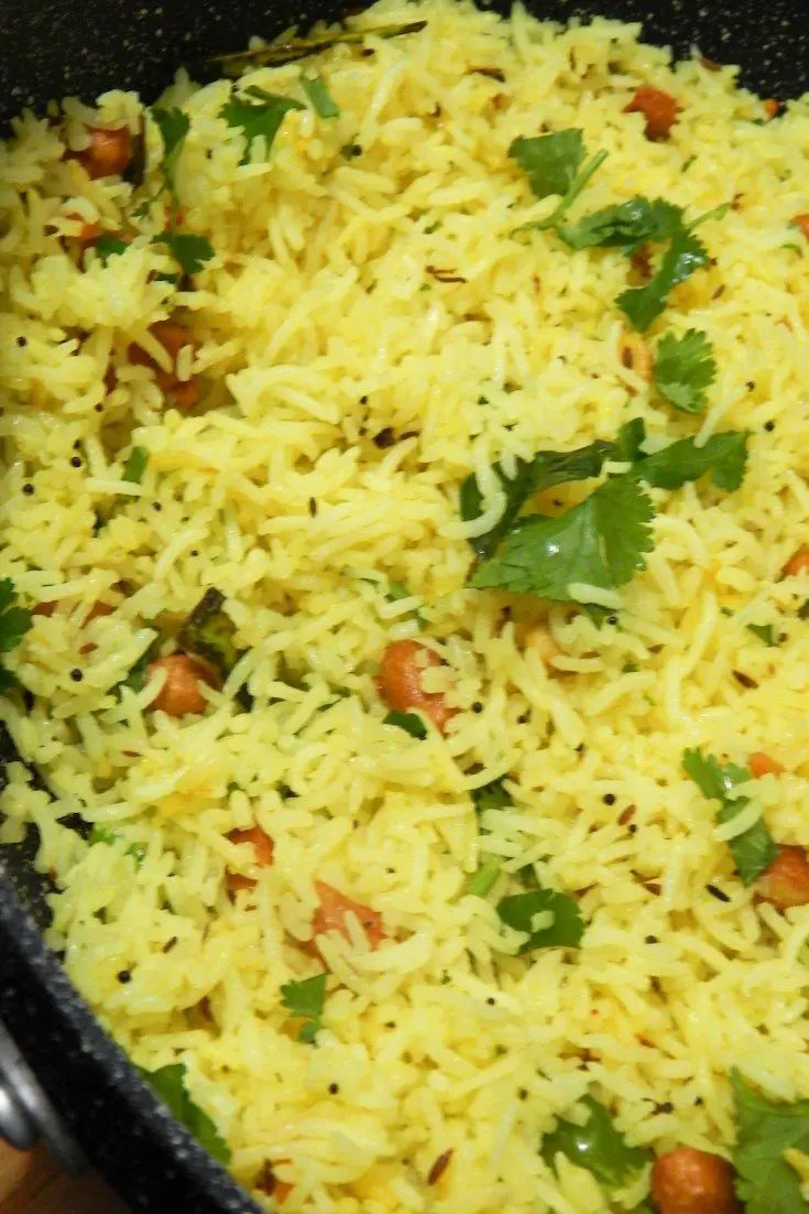 a pan filled with rice and garnished with cilantro on the side