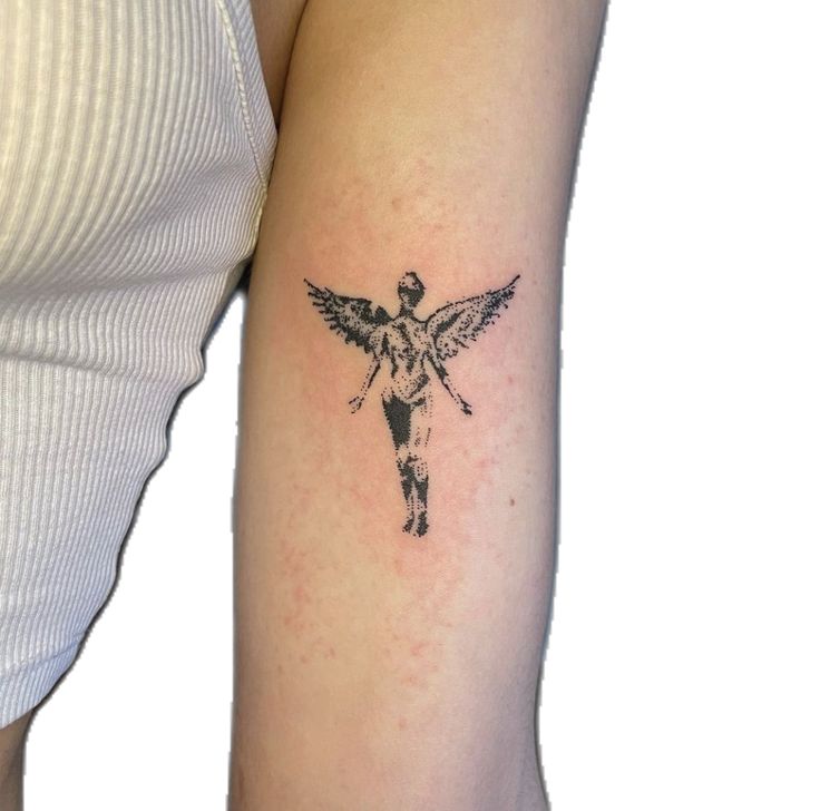 a woman's arm with a tattoo on it that has an angel and cross