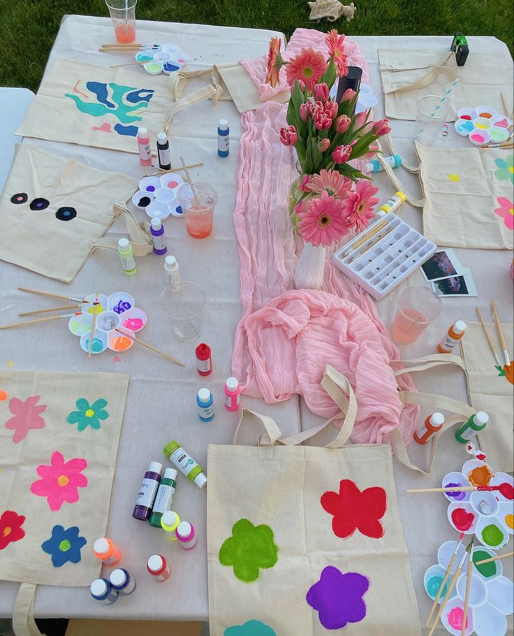 the table is covered with paper flowers and craft supplies