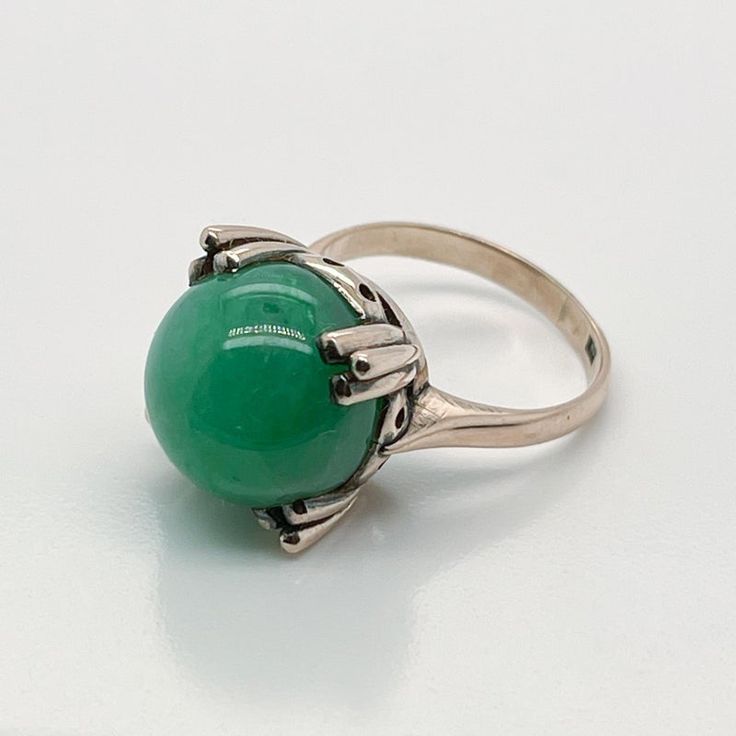 A very fine 14k gold and jade bead Art Deco style ring.  With a large jadeite bead prong set in a 14k gold architectural setting.  Simply a wonderful ring!  Date: Early to Mid 20th Century  Overall Condition: It is in overall good, as-pictured, used estate condition. There is mottling and a fine natural fissure visible to the top of the stone, as well as some very fine & light surface scratches and other signs of expected light wear consistent with age.  Fineness: Marked 14K for gold fineness. Formal Jade Jewelry For May Birthstone, Formal Jade Ring Jewelry, Fine Jewelry Chrysoprase For Formal Occasions, Formal Round Jade Jewelry, Formal Jade Rings For May Birthstone, Green Cabochon Dome Ring For Formal Occasions, Antique Green Emerald Ring With Polished Finish, Fine Jewelry Jade Ring For Formal Occasions, Formal Fine Jewelry Jade Rings