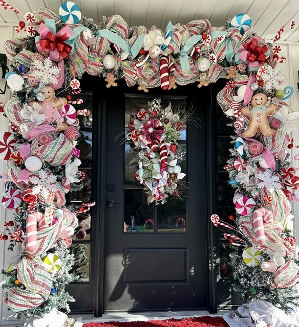 the front door is decorated for christmas with candy canes and wreaths on it