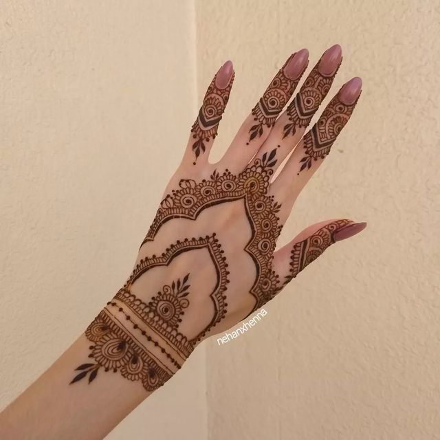 a woman's hand with henna tattoos on it