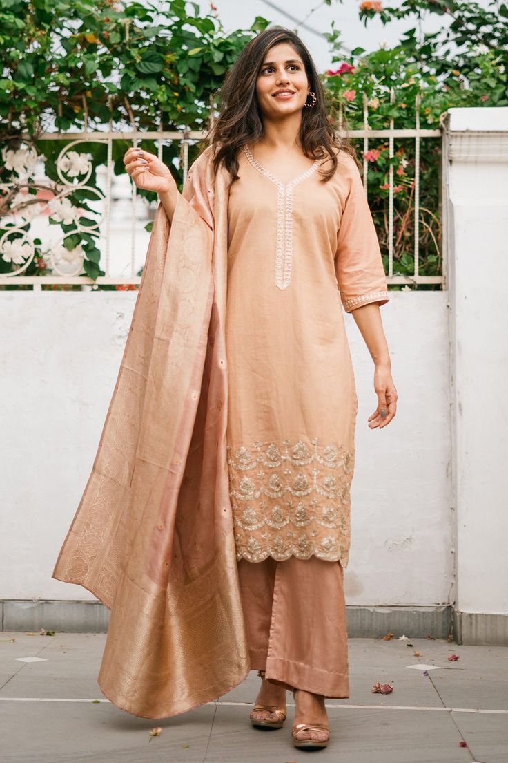 Nude cotton embroidered kurta in gota work. Paired with solid pant and dupatta.
Component: 3
Pattern: Embroidered
Type Of Work: Gota work
Neckline: Leaf neck
Sleeve Type: Three quarter
Fabric: Cotton, Cotton Silk, Banarasi
Color: Beige
Other Details: 
Banarasi dupatta
Scallop hem kurta
Occasion: Reception,Wedding - Aza Fashions Unstitched Straight Kurta Palazzo Set With Gota Work, Eid Chanderi Unstitched Suit With Gota Work, Chanderi Palazzo Set With Resham Embroidery For Diwali, Chanderi Sets With Gota Work For Eid, Eid Gota Work Chanderi Unstitched Suit, Mulmul Saree Set With Gota Work, Bollywood Style Unstitched Cotton Silk Suit With Gota Work, Eid Chanderi Palazzo Set With Gota Work, Elegant Cotton Anarkali Set With Gota Work