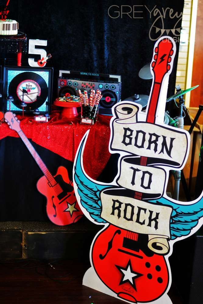 a sign that says born to rock with guitars and clocks in the backgroud