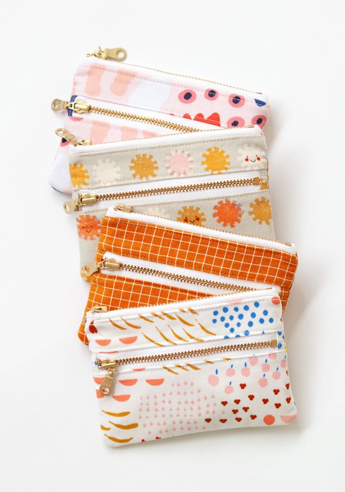 four zippered pouchs lined up on top of each other, with different patterns