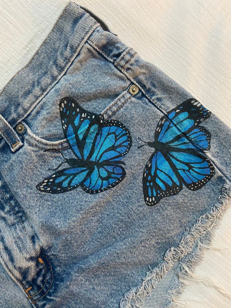 Short Pocket Painting, Denim Short Painting Ideas, Jeans Painting Butterfly, Fabric Paint Designs On Jeans, Denim Shorts Painting, Fabric Painting Jeans, Jeans Acrylic Paint, Drawing On Shorts, Painting In Jeans