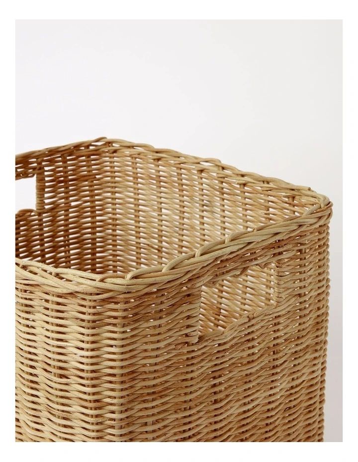 an empty wicker basket with handles on the bottom is shown in front of a white background