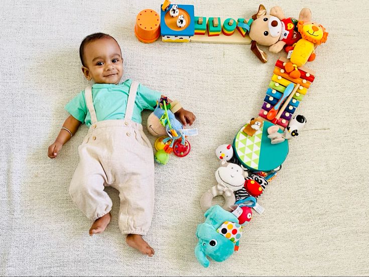 a baby laying on the floor next to toys