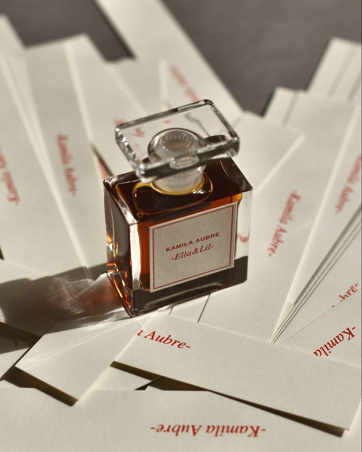 a bottle of perfume sitting on top of envelopes