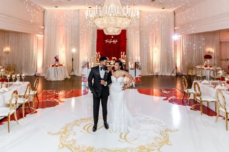 a bride and groom posing for a photo in the ballroom at their wedding reception venue