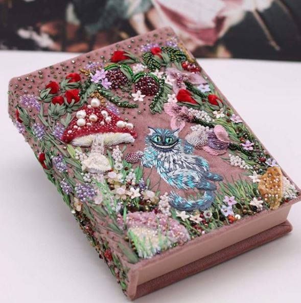 a small book covered in flowers and plants