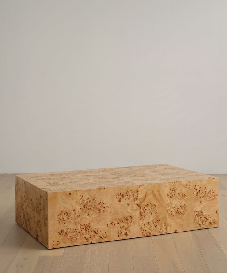 a wooden box sitting on top of a hard wood floor next to a white wall