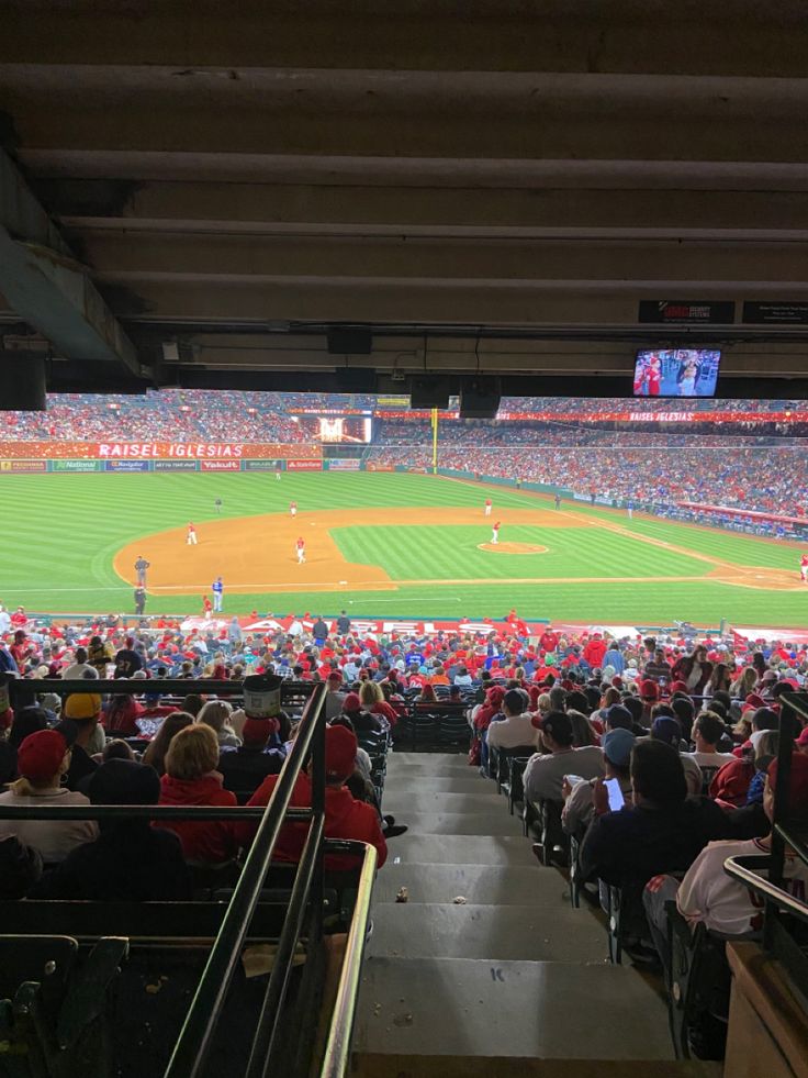 a baseball stadium filled with lots of people sitting in the bleachers watching a game