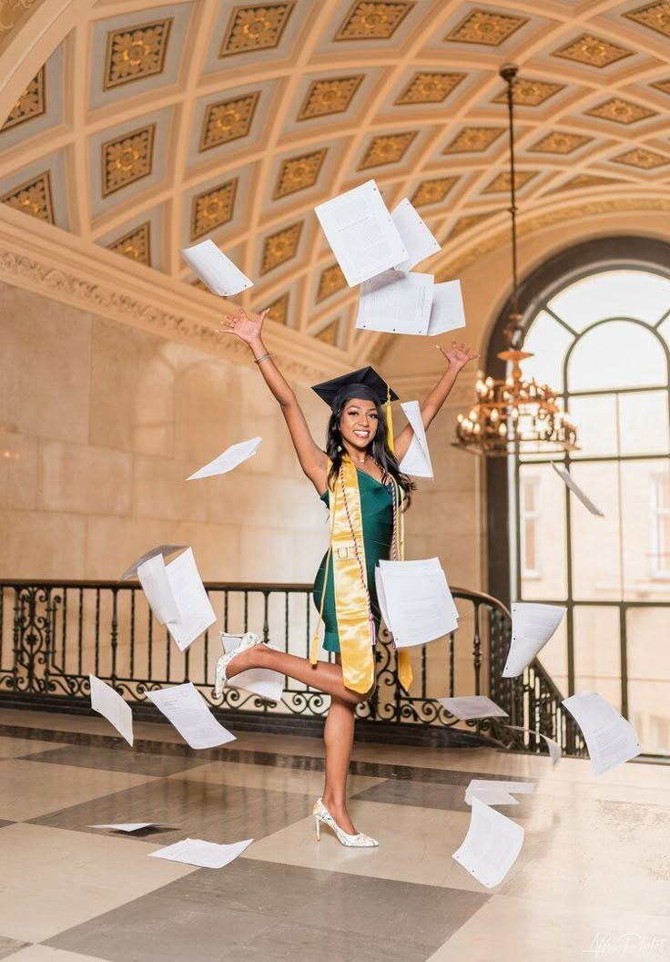 a woman in a graduation gown is throwing papers into the air