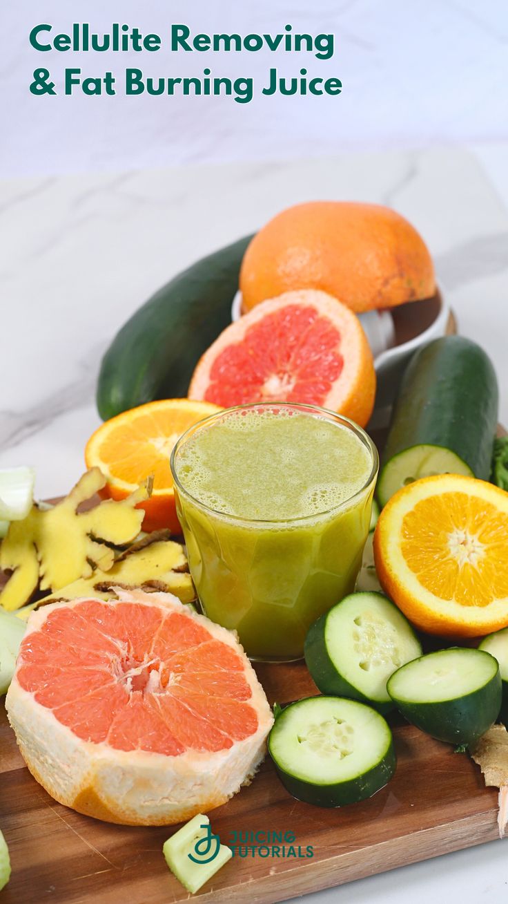 an orange and cucumber smoothie is on a cutting board with sliced fruit