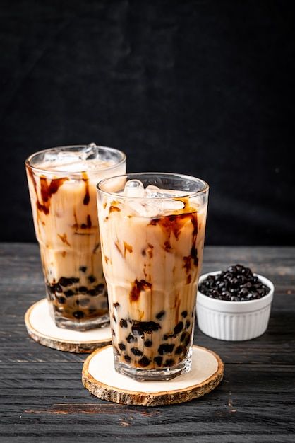 two glasses filled with ice cream sitting on top of a wooden table