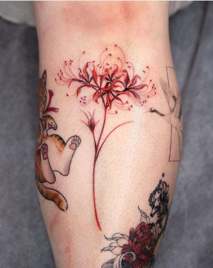 a woman's leg with tattoos on it and flowers in the middle of her legs