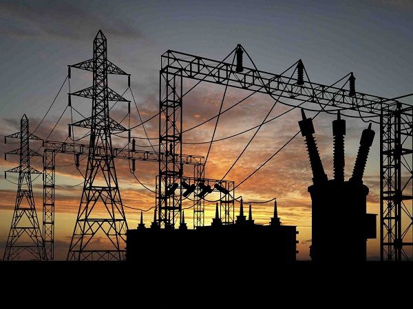 the silhouette of power lines against an orange and blue sky with clouds in the background