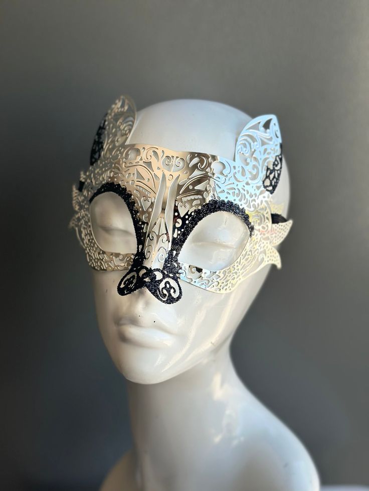 This mask takes inspiration from the elusive and enchanting lemur, adding a touch of intrigue and mystique to your look. The striking contrast of silver with black glitter exudes an air of opulence and charm. Whether you're attending a grand masquerade ball, a themed gala, or simply looking to add a touch of exotic elegance to your attire, this mask ensures you'll be the center of attention.


Age Group/Gender - Adult/Unisex

Size/Type - One size fits all adults

Mask Color - Silver/Black

Mask Silver Gothic Eye Mask For Masquerade, Silver Gothic Mask For Costume Party, Gothic Silver Mask For Costume Party, Gothic Silver Eye Masquerade Mask, Silver Gothic Eye Masquerade Mask, Silver Masquerade Mask For Carnival Theater, Silver Masquerade Mask For Theater And Carnival, Silver Masks And Prosthetics For Mardi Gras Theater, Silver Gothic Mask For Masquerade