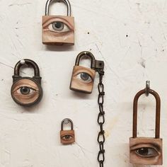 four padlocks with eyes on them and one has a chain attached to it