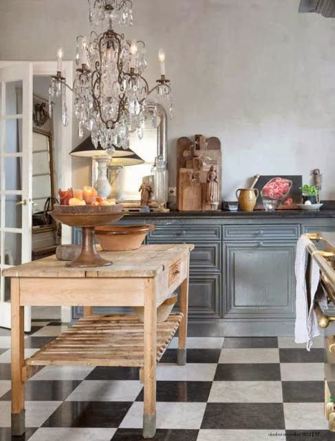 a kitchen with black and white checkered flooring next to a chandelier