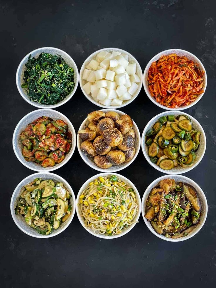 bowls filled with different types of food on top of a black countertop next to each other