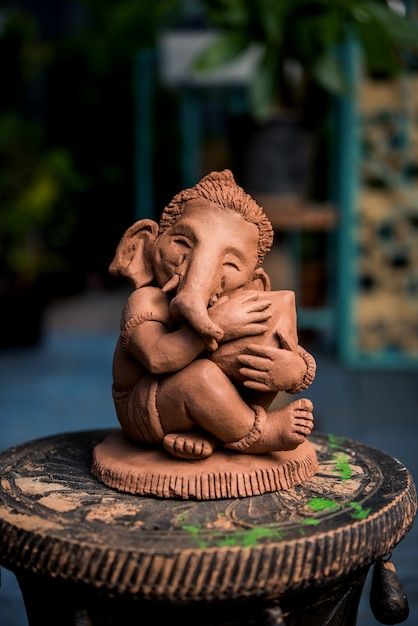 an elephant statue sitting on top of a wooden stump with the caption, lord ganeshh